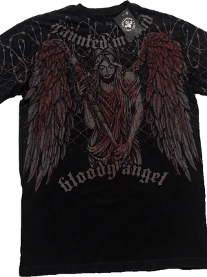 Affliction Haunted Mound Bloody Angel Tee t-shirt - Skicka Bud släpper för rätt pris‼️‼️‼️100% Autentisk Haunted Mound Affliction colab T shirt. Tröjan är helt ny och aldrig använd och kommer inte att använda alls. Fråga om flera bilder ifall de behövs strlk m. 