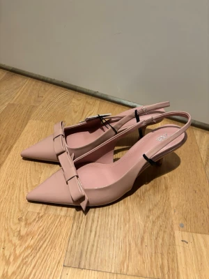 Slingbacks Zara - Snygga ljusrosa pumps från Zara med spetsig tå och  rosettdetalj framtill. Nya med prislapp