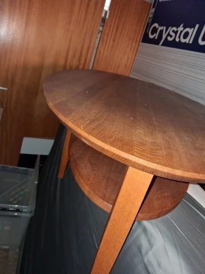 TANGO soffbord i mörkt trä - Säljer ett runt soffbord i mörkbrunt trä med en extra hylla undertill. Bordet har tre ben och en stilren, klassisk design som passar perfekt i vardagsrummet. Materialet är trä och formen är rund.