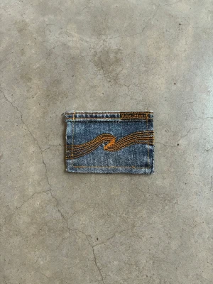 Jeansplånbok - Dropp 6  Handsydd plånbok i vintage jeans. Varje exemplar är unikt med snygga detaljer. Plånboken håller flera kort utan att dem åker ut. Små variationer i färg och struktur visar på plaggets tidigare historia💙  Tiktok: Jeanius.bc