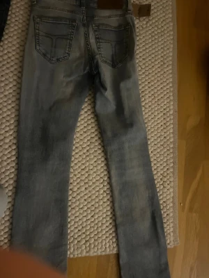 TAR BORT!!! - Säljer ett par ljusblå jeans med raka ben och klassiska bakfickor. Jeansen har en snygg tvättad vintage-look och detaljerade sömmar. Passar perfekt till en avslappnad stil och har bälteshällor samt läderpatch bak i midjan.