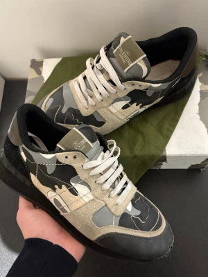 Valentino rockrunners - Säljer dessa valentino rockrunner skor | Storlek 45 | Ganska dåligt skick, defekter syns i bild, limmade fram och bak | Förstörd låda då tidigare ägare tejpat på den | Skor, box, dustbag, kort och snören medföljer | Skriv vid minsta fråga eller fundering 🤝
