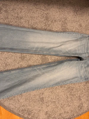 Lågmidjade populära jeans från Zara - Säljer ett par ljusblå jeans från Zara med rak passform och klassisk femficksdesign. Jeansen har en snygg tvättad look och är tillverkade i bomull. Nypris 399