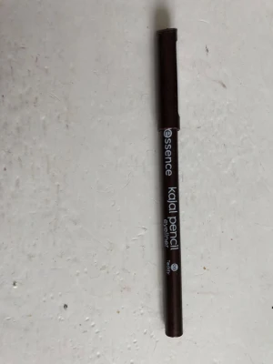 Essence kajalpenna eyeliner brun - Mjuk kajalpenna från Essence i en djup brun nyans. Pennan har klassisk träform och är enkel att vässa för precis applicering. Perfekt för att skapa definierade eller sotade ögonlooks. Smidig att ta med i sminkväskan.