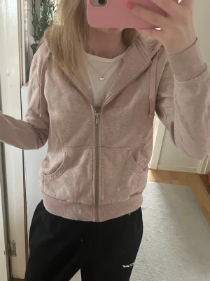 Ljusrosa hoodie med dragkedja - Säljer en ljusbeige hoodie med dragkedja framtill och två stora fickor. Hoodien är i rosa och i mycket bra skick💕
