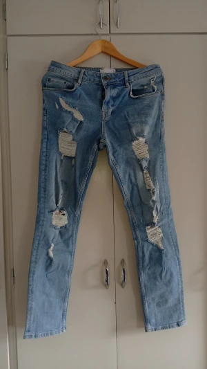 ASOS Jeans - ASOS Design jeans i mycket bra skick. Ljusblå tvätt med snygga slitna detaljer – passar perfekt till sneakers och hoodie. Storlek W30/L32. Säljs eftersom de inte används