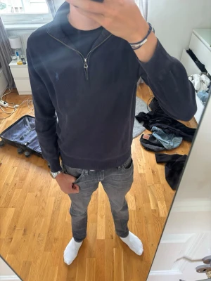 Mörkblå stickad halvzip från Polo Ralph Lauren - En av de bästa plaggen jag har ägt. Passar från casual till mer uppklädda tillfällen. Nypris ca 2200 kr.                                                                Armlängd:47 cm.                                           Brösstvid: ca 50 cm                                             Längd: ca 60 cm( från kragens sömn)