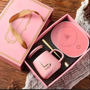 Presentset mugg och värmeplatta fint - Lyxigt presentset med keramikmugg, matchande värmeplatta, lock och sked. Finns i rosa och mörkgrönt med gulddetaljer och texten 'Lucky'. Allt levereras i en elegant presentförpackning med bandhandtag. Perfekt för te- eller kaffedrickare som gillar snygga dealer  fina muggar.