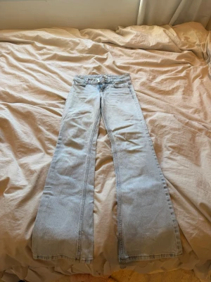 Ljusblå utsvängda jeans Pull&Bear - Säljer ett par ljusblå jeans från Pull&Bear med utsvängda ben och klassisk femficksmodell. Jeansen har låg midja och är tillverkade i denim med en snygg tvätt. Perfekta för dig som gillar retrostil och vill ha ett par trendiga jeans i garderoben. Använda få gånger, säljer för dem blivit för små!💞