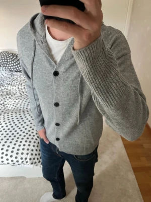 Grå stickad hoodie med knappar  - Grå stickad hoodie med knappar. Stilren och snygg och funkar i alla situationer! 😁