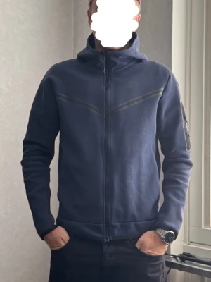 Mörkblå Nike tech tröja - Hjälper min kille att få sålt sin tröja från Nike. Den är i mycket gott skick och säljs då den inte kommer till användning. Nypris 1300kr säljer för 500kr då han vill bli av med den!😊hör av dig vid frågor.