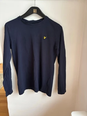 Mörkblå långärmad topp - En stilren mörkblå långärmad Lyle&Scott i st 12-13år.  
