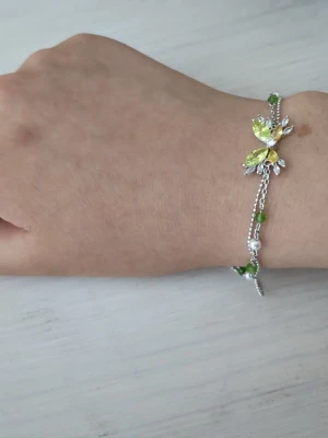 Silverarmband med fjäril och pärlor - Snyggt armband i silverfärg med en dekorativ fjäril i gult och grönt samt små vita och gröna pärlor längs kedjan. Köpt i en smyckesbutik i Kina🌸 perfekt för sommaren