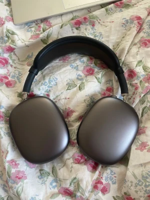 Apple AirPods Max grå over-ear hörlurar - Snygga over-ear hörlurar från Apple i en stilren grå färg. Perfekta för musik, gaming eller videos. Trådlösa och med riktigt bra ljudkvalitet. 1a generationen som idag har vanlig Lightning kabel. Skal medföljer men ingen kartong, väl använda men i gott skick! Ibland hoppar den ur bluetooth men går enkelt att koppla tillbaka, några skavanker som bild visar men inget som syns så mkt. Bygeln är ersatt med gummi ist för tyg (bortklippt från tidigare ägare) pga bättre stöd mot huvudet. Funkar toppen 