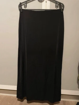Svart midi kjol - Svart midikjol från h&m i storlek s med resår i midjan och slits baktill, mycket gott skick!