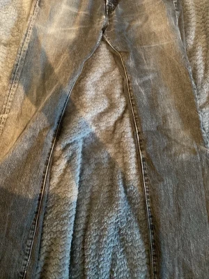 Grå LEVI jeans - Säljer ett par grå jeans med rak passform och klassisk femficksdesign. Jeansen har en snygg tvättad look och är tillverkade i denim. Perfekta för dig som gillar en avslappnad och tidlös stil.                      W31.   L32