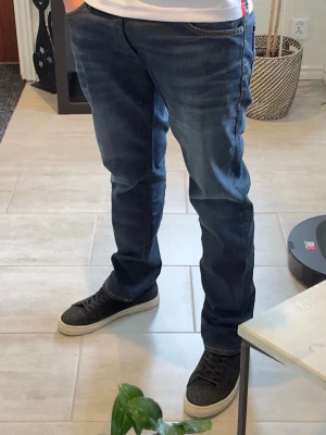 Jack & Jones slim straight jeans W32/L32 - Mörkblå jeans från Jack & Jones i modellen Slim Straight Tim. Snygg passform med lätt stretch och clean wash som passar till allt. Storlek W32/L32. Bra skick överlag, liten slitning/hål vid bakfickan finns (se sista bild).  Modellen på bilden är ca 185 cm lång och väger ca 78 kg för referens.