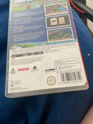 RollerCoaster Tycoon Adventures Deluxe Switch - RollerCoaster Tycoon Adventures Deluxe till Nintendo Switch. Bygg och hantera nöjesparker med massor av åkattraktioner och banor. Spelet kommer på ett svart plastkort med färgglad etikett och levereras i originalförpackning. Perfekt för dig som gillar strategi och simulering.