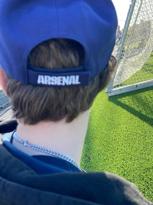 Mörkblå Arsenal keps från '47 - Snygg mörkblå keps från '47 med Arsenal-logga broderad framtill och texten 'ARSENAL' baktill. Justerbar passform och böjd skärm. Perfekt för dig som vill visa ditt stöd för Arsenal på ett stilrent sätt.