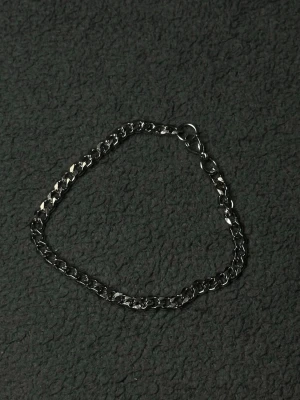 Silver Cubansk Armband 21cm 5mm i Rostfritt Stål - Stilrent cubanskt armband i silverfärg. Tillverkat i rostfritt stål som inte rostar eller tappar färg lätt. Perfekt vardagsaccessoar som funkar både ensam eller ihop med andra smycken. 5mm tjocklek ger en clean men tydlig look på handleden.