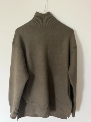 Olivgrön polotröja från H&M - Stickad olivgrön polotröja från H&M med slits längst ner i storlek XS men är oversized, använd 1 gång