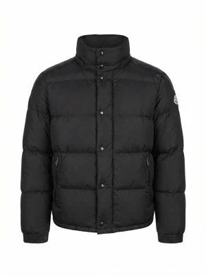 Svart pufferjacka från Moncler - Svart pufferjacka från Moncler med hög krage, dragkedja och tryckknappar framtill. Jackan har två fickor med dragkedja och Moncler-logga på ärmen. Materialet är glansigt på axelpartiet och matt på resten av jackan. Perfekt för kalla vinterdagar.