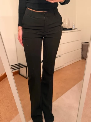 Svarta kostymbyxor från BikBok - Snygga svarta kostymbyxor från BikBok med raka ben och klassisk passform. Byxorna har hällor för skärp, fickor fram och stängs med dragkedja och knapp. Perfekta för en stilren look. Helt nya 