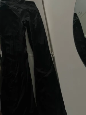Svarta utsvängda leggings - Snygga svarta leggings med utsvängda ben och hög midja. Perfekta  från Bikbok
