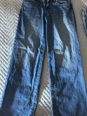 Blå raka jeans från Perfect Jeans - Säljer ett par klassiska blå jeans från Perfect Jeans i rak modell. Jeansen har normalhög midja, dragkedjegylf och bälteshällor. Perfekta till en avslappnad stil och funkar året runt. Materialet är klassisk denim i bomull.