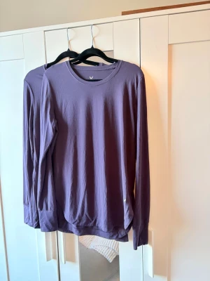 Lila långärmad topp i bomull - En basic lila långärmad topp med rund halsringning. Tillverkad i mjuk bomull, perfekt för lager-på-lager eller som den är. Enkel och stilren design utan synliga detaljer.