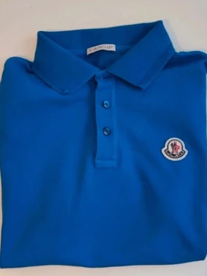 Blå pikétröja från Moncler - Snygg orginal pike från Moncler. Minimal svanker se sista bild, känns och ser som ny annars. 