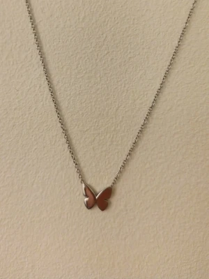 Edblad halsband med fjäril  - Snyggt halsband från Edblad. Helt nytt, men utan prislapp. Nypris: 349kr. Kedjan är tunn och smidig, och fjärilen har en stilren, minimalistisk design. Perfekt accessoar för att lyfta din outfit med en söt detalj.