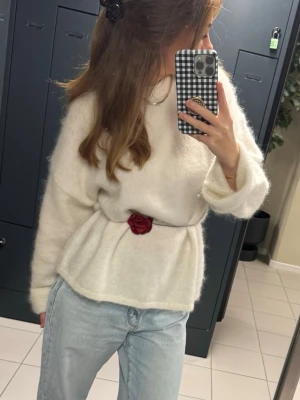 Vit oversized mohairtröja - Mysig vit stickad tröja med fluffig textur och avslappnad passform. Tröjan har långa ärmar och är perfekt att styla med jeans för en trendig look. OBS!! Rosen i midjan tillhör ej!! Nypris: 800kr