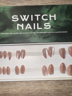 Switch Nails Champagne Cat Eye - Press-on naglar i färgen Champagne Cat Eye med skimrande finish. Formen är kort mandel (almond short) och naglarna är återanvändbara samt tillverkade av återvunnet material. Perfekt för dig som vill ha snygga naglar snabbt och enkelt. Säljes utan tillbehör. 