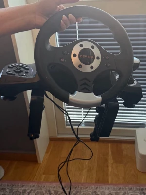 Simulator ratt med pedaler - Säljer en svart ratt från Cepler för spelkonsol. Ratten har knappar. Perfekt för racing- och bilspel för en mer realistisk spelupplevelse.