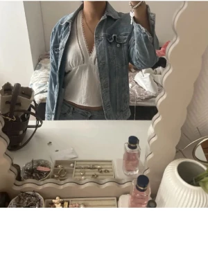 Ljusblå jeansjacka från ZARA - Snygg ljusblå jeansjacka från ZARA med klassisk passform och silverfärgade knappar. Jackan har två bröstfickor med lock och två sidofickor. Perfekt för att lyfta vilken outfit som helst.