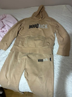 Beige loungewear-set från Hoodrich - Säljer ett beige loungewear-set från Hoodrich i storlek medium. Setet består av en hoodie med magficka och matchande byxor, båda med Hoodrich-logga framtill. Mjukt material, perfekt för chill dagar hemma