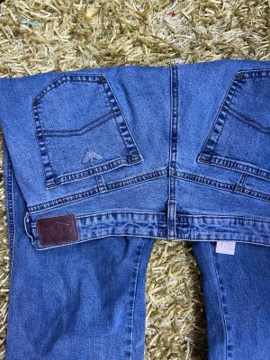 Emporio Armani raka blå jeans - Emporio Armani jeans i klassisk blå denim med raka ben och logga på bakfickan. Jeansen har normal midja, fem fickor och en läderpatch med logotyp bak. Perfekta för en stilren och avslappnad look. Priset är förhandlingsbart 