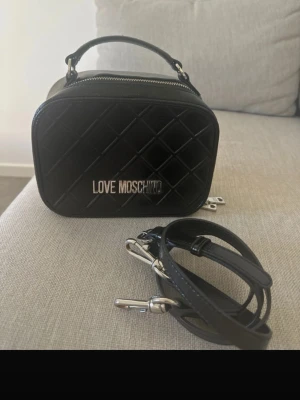 Moschino väska - Bra skick! Axelrem medföljer (original) bredd 20cm, höjd 15 cm