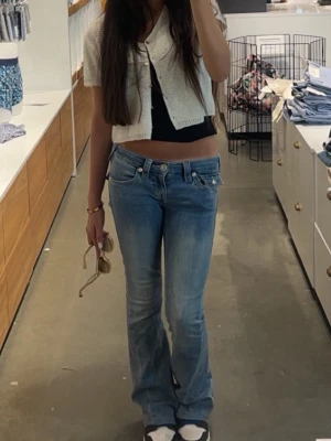 w23 True Religion ljusblå bootcut jeans - pris kan diskuteras. Säljer ett par ljusblå jeans från True Religion med bootcut passform och låg midja. Jeansen har klassiska fickor med lock och silverfärgade knappar bak, samt snygga sömdetaljer. Materialet är jeans och de har en cool, avslappnad vibe. w23 