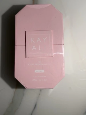 Kayali Yum Boujee Marshmallow 100ml - Kayali Yum Boujee Marshmallow 81 i en snygg rosa, åttakantig kartong. Doften är söt och gourmand med marshmallow-toner. Flaskan rymmer 100 ml och förpackningen har en modern, lyxig känsla.