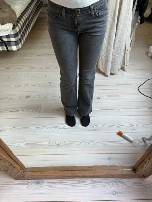 Grå Levi's bootcut jeans - Säljer ett par gråa Levi's jeans med bootcut passform och klassiska fem fickor. Jeansen har en snygg tvättad look och ikonisk läderpatch bak i midjan. Perfekta för en avslappnad och trendig stil.