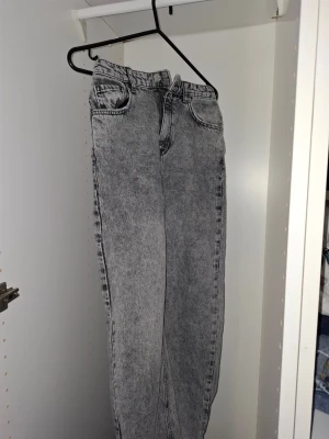  jeans  - Snygga grå jeans med och hög midja. Klassisk femficksmodell och raka ben. Jeansen har bälteshällor och stängs med dragkedja och knapp. Perfekta för en trendig och avslappnad stil. Storlek 158