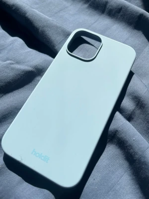 Ljusblått iPhone 14 skal från holdit - Snyggt ljusblått mobilskal från holait med stilren design. Skalet är gjort i mjukt silikonmaterial och har en slät yta. Perfekt passform för mobil med stor kameramodul. Enkel att ta av och på.