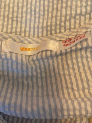 Randig linnetopp från Gina Tricot - Söt ljusblå och vit randig linnetopp från Gina Tricot med tunna axelband och volangkant nedtill. Perfekt för varma dagar och enkel att styla med jeans eller kjol. Luftigt material som känns skönt mot huden.