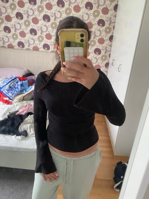 Svart långärmad topp Gina Tricot - Säljer en svart långärmad topp från Gina Tricot. Modellen är tight med utsvängda ärmar och lätt rynkade sidor som ger en snygg siluett. Toppen är i mjuk bomullsmix och har en enkel, stilren look som passar till det mesta.