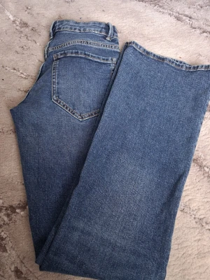 NYA - Blå bootcut jeans från Lindex - Säljer ett par klassiska blå bootcut jeans från Lindex. Jeansen har fem fickor, normal midja och snyggt slitna detaljer. Tillverkade i denim med en autentisk tvättad look och flared lool. De är helt nya och oanvända, tog emdast bort lapparna, men sen ångra jag mig! 😃