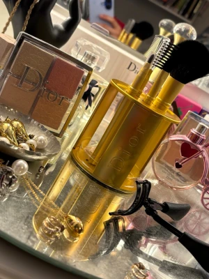 Dior unikt make-up pensel-set✨💄 - Exklusivt och unikt make up pensel-set från Dior i elegant guldfinish - en perfekt kombination av funktion och lyx. 💫💄  Setet innehåller puder/rouge-borste, ögonbryns-kam, ögonskuggs-pensel samt lappstifts-pensel, stilrent presenterade i ett dekorativt cylinderställ med ikonisk Dior-logo.✨💫  Den sofistikerade designen gör detta till både en praktisk accessoar och en exklusiv inredningsdetalj för badrum eller dressing room.  Perfekt för dig som uppskattar premiumkänsla, tidlös estetik och kvalite