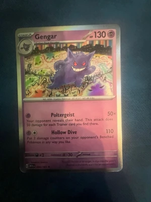 Pokémonkort Gengar 094/165 - Säljer ett holografiskt Pokémonkort med Gengar. Kortet har lila och guldfärgade detaljer, med Gengar i centrum och färgglad bakgrund. Kortet har attacker som Poltergeist och Hollow Dive och HP 130. Perfekt för samlare eller Pokémonfans.