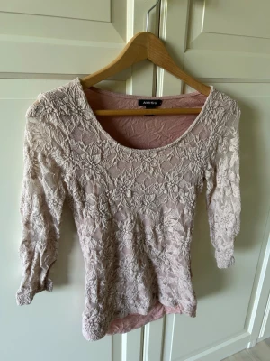 Beige spetsblus från Amisu - Supersöt beige blus från Amisu med blommig spets och trekvartsärm. Toppens material är genombruten spets som ger en romantisk vibe och den har en rundad halsringning. Perfekt att styla med jeans eller kjol för en trendig look. Har även i vitt!